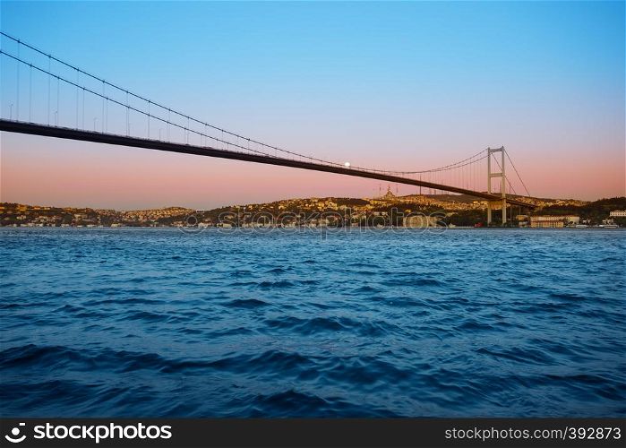 Bridge over the Bosphorus in the twilight dawn under a bright moon. Istanbul, Turkey. Night landscape.. Bridge over Bosphorus in twilight dawn under bright moon