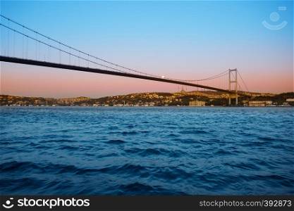 Bridge over the Bosphorus in the twilight dawn under a bright moon. Istanbul, Turkey. Night landscape.. Bridge over Bosphorus in twilight dawn under bright moon