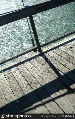 Bridge railing detail with shadows on decking.