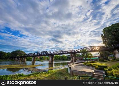 Bridge River Kwai with blue sky and sun in Kanchanaburi, Thailand