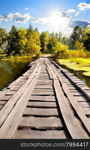 Bridge through river in sunny autumn day