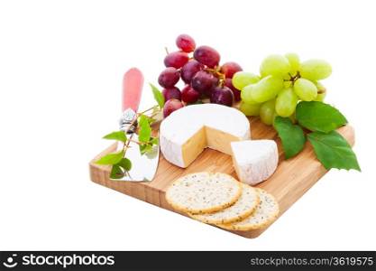 Brie Cheese and crackers with grapes on a white .