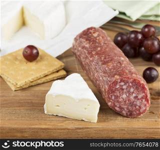 Brie Cheese And Salami On A Wooden Cutting Board