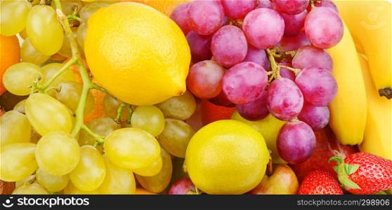 Bright beautiful background of ripe fruits. Organic healthy food. Wide photo.