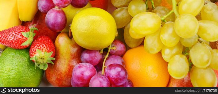 Bright beautiful background of ripe fruits. Organic healthy food. Wide photo.