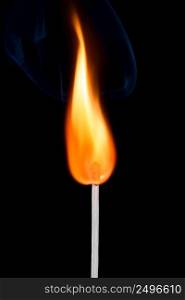 Bright burning match stick with fire and smoke isolated on black background
