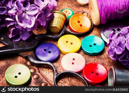 Bright buttons and lilac branch. Set buttons from clothes, threads and scissors.Sewing accessories.
