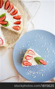 Bright cheesecake decorated with fresh strawberries and basil leaves, cut one piece on a plate.. Bright cheesecake decorated with fresh strawberries and basil leaves, cut one piece on a plate