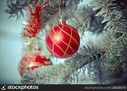 bright Christmas bauble from a snow covered Christmas Tree Branch