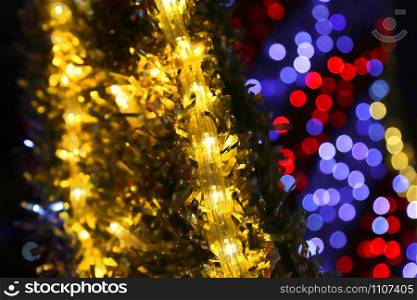 Bright Christmas decoration, colorful lights of bulbs, garlands and shiny tinsel, abstract background out of focus