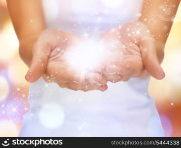 bright closeup picture of magic twinkles on female hands