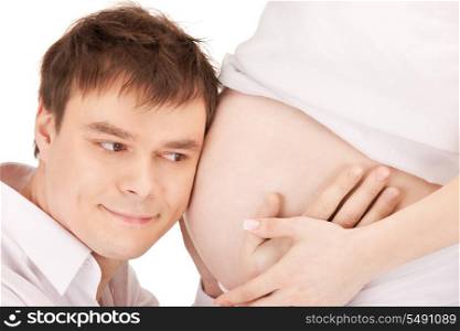 bright closeup picture of male face and pregnant woman belly