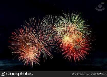 Bright colored fireworks on a black background. Celebration and holidays concept. New Year, Independence Day, July 4 Festival. Bright explosions of lights in the sky. Place for your text.. Bright colored fireworks on black background. Celebration and holidays concept. New Year, Independence Day, July 4 Festival. Bright explosions of lights in the sky.