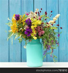 Bright colorful bouquet of wild flowers in starm tin can vase on background blue wooden boards. Template for postcard or your design Concept Women's day or Mothers Day, Hello summer Hello spring.. Bright colorful bouquet of wild flowers in starm tin can vase on background blue wooden boards. Template for postcard or your design Concept Women's day or Mothers Day, Hello summer Hello spring