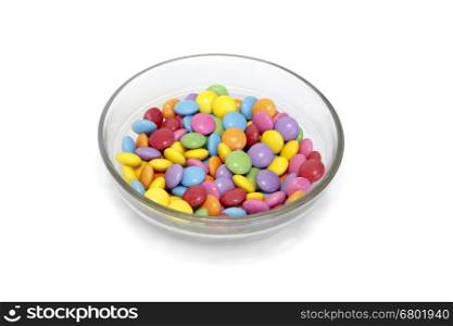 Bright colorful candy in bowl isolated on white background