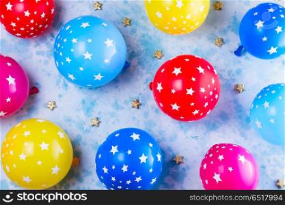 Bright colorful carnival or party scene. Bright colorful carnival or party pattern of balloons on blue table. Flat lay style frame, birthday or party greeting card