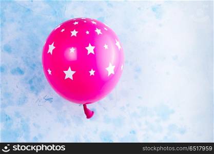 Bright colorful carnival or party scene. Bright colorful carnival or party scene of pink balloon on blue table. Flat lay style, birthday or party greeting card with copy space.