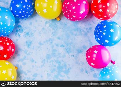 Bright colorful carnival or party scene. Bright colorful carnival or party scene frame of balloons on blue table. Flat lay style, birthday or party greeting card with copy space.