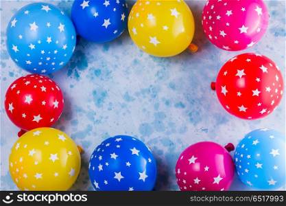 Bright colorful carnival or party scene. Bright colorful carnival or party scene frame of balloons on blue table. Flat lay style frame, birthday or party greeting card with copy space.