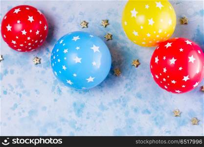 Bright colorful carnival or party scene. Bright colorful carnival or party scene of balloons on blue table background. Flat lay style, birthday or party greeting card with copy space.