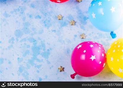 Bright colorful carnival or party scene. Bright colorful carnival or party scene of balloons on blue table. Flat lay style, birthday or party greeting card with copy space.