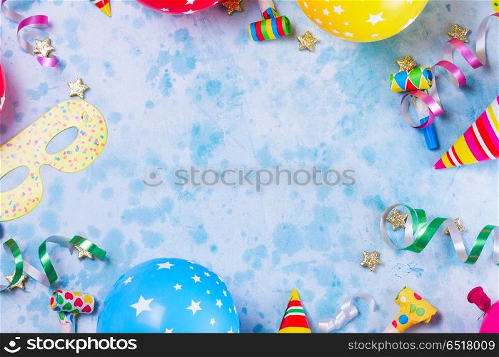 Bright colorful carnival or party scene. Bright colorful carnival or party scene frame of balloons, streamers and confetti on blue. Flat lay style, birthday or party greeting card with copy space.