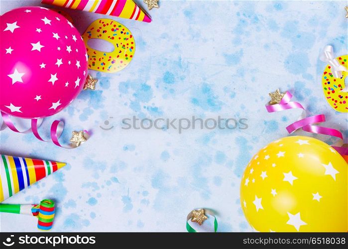Bright colorful carnival or party scene. Bright colorful carnival or party scene of balloons, streamers and confetti on blue. Flat lay style, birthday or carnival party greeting card with copy space.