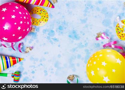 Bright colorful carnival or party scene. Bright colorful carnival or party scene of balloons, streamers and confetti on blue. Flat lay style, birthday or carnival party greeting card with copy space.