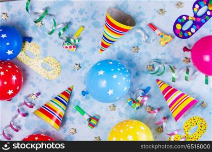 Bright colorful carnival or party scene. colorful carnival or party pattern of balloons, streamers and confetti on blue table. Flat lay style, birthday or party greeting card.