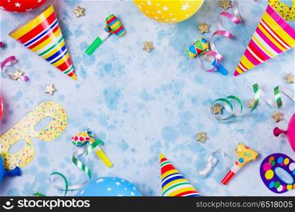 Bright colorful carnival or party scene. colorful carnival or party scene frame of balloons, streamers and confetti on blue table. Flat lay style, birthday or party greeting card with copy space.