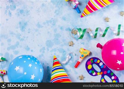 Bright colorful carnival or party scene. colorful carnival or party scene frame of balloons, streamers and confetti on blue table. Flat lay style border, birthday or party greeting card with copy space.
