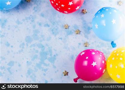 Bright colorful carnival or party scene. colorful carnival or party scene of balloons on blue table. Flat lay style, birthday or party greeting card with copy space.