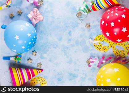 Bright colorful carnival or party scene. colorful carnival or party scene of balloons, streamers and confetti on blue table. Flat lay style, birthday or carnival party greeting card with copy space.