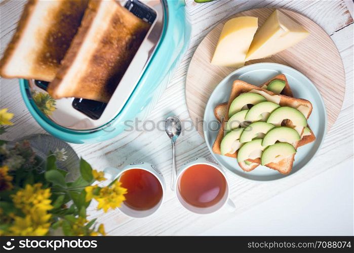 bright, fun breakfast. cyan color toaster on a wooden background