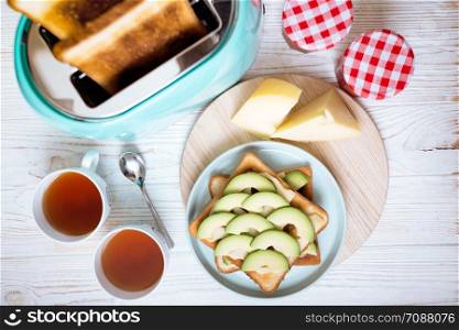 bright, fun breakfast. cyan color toaster on a wooden background