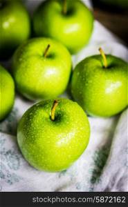 Bright green apples on wooden background
