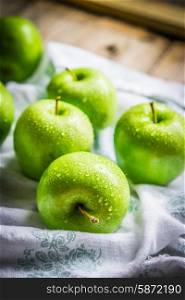 Bright green apples on wooden background