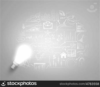 Bright idea for business growth. Glass glowing light bulb and business sketched ideas