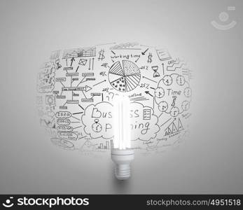 Bright idea for business growth. Glass glowing light bulb and business sketched ideas