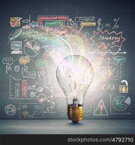 Bright idea for success. Glass glowing light bulb and business sketched ideas