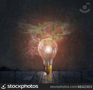 Bright idea for success. Glass glowing light bulb as idea sign on concrete background