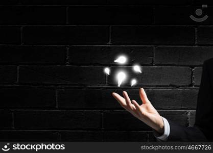 Bright idea in hand. Businessman with illuminated glass light bulb in hand