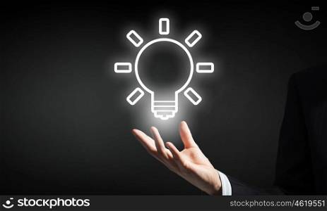 Bright idea in hand. Businessman with illuminated idea bulb in hand