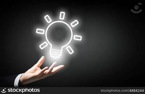 Bright idea in hand. Businessman with illuminated idea bulb in hand