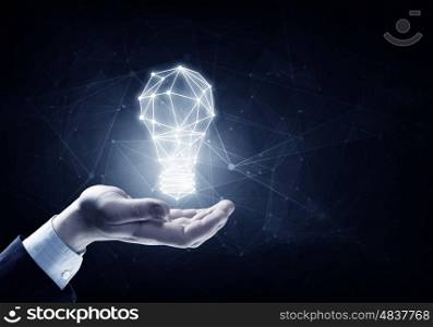Bright idea in hand. Hands of business person holding illuminated light bulb sign