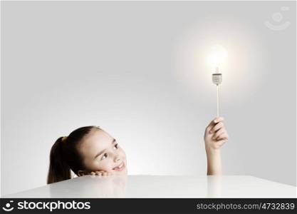 Bright idea. Little cute school girl and electric bulb