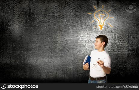 Bright idea. Smiling school boy glasses and books in hands