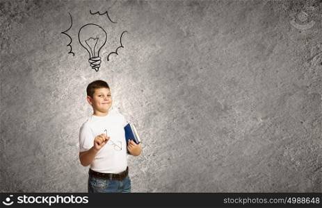 Bright idea. Smiling school boy glasses and books in hands