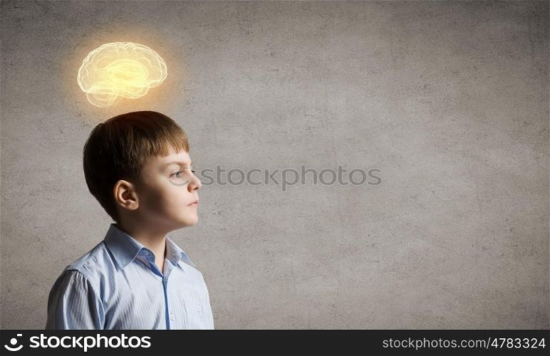 Bright idea. Young boy of school age looking thoughtfully away