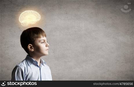 Bright idea. Young boy of school age looking thoughtfully away